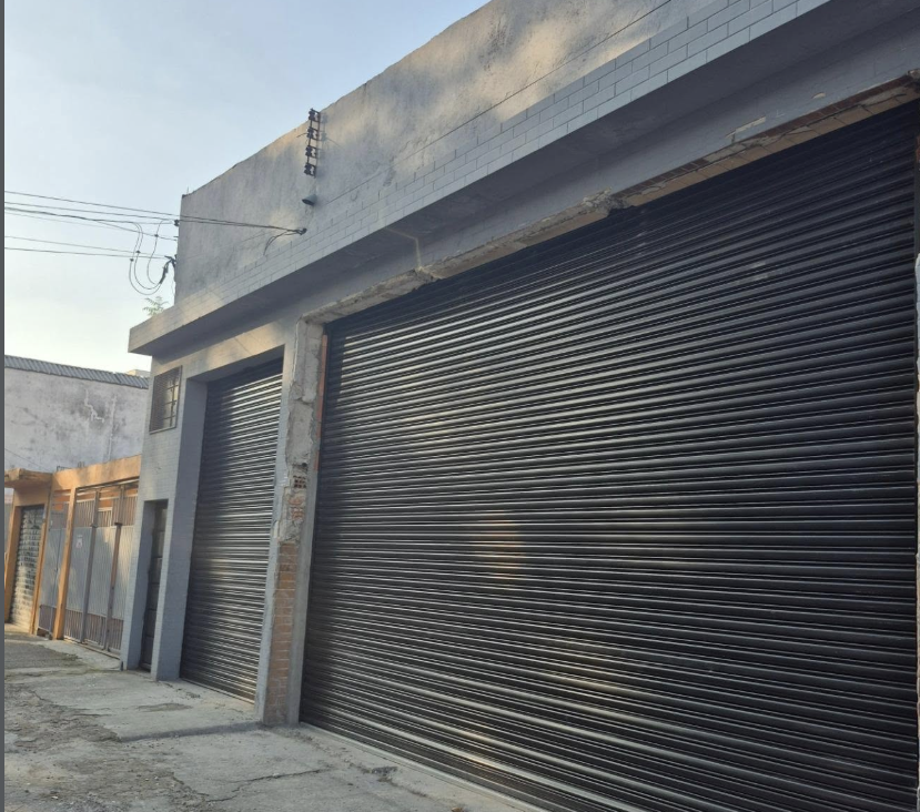 Portas de enrolar pretas instaladas em galpão comercial